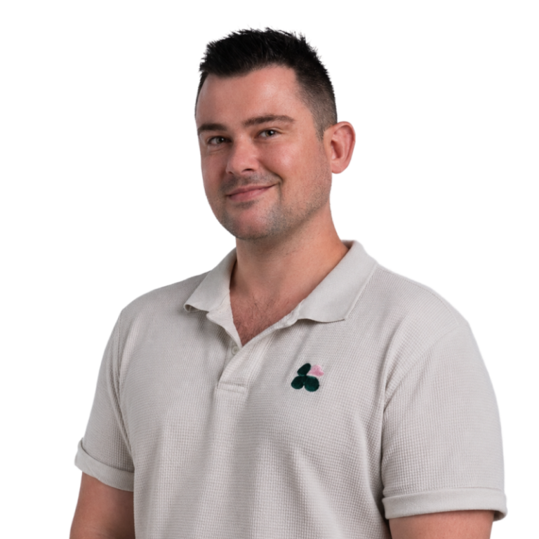 Man in beige polo smiling at camera